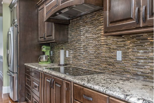 Image of kitchen with granite countertops and rustic looking brown cabinets