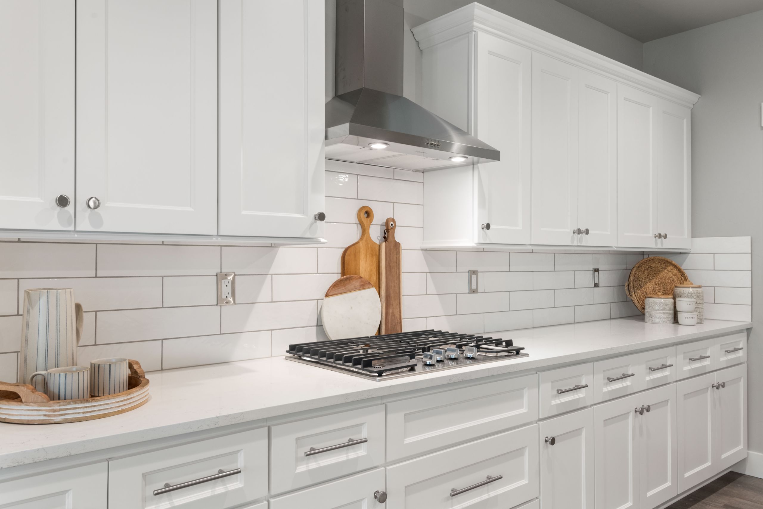 Image of a white kitchen with white granite countertops, and white cabinets